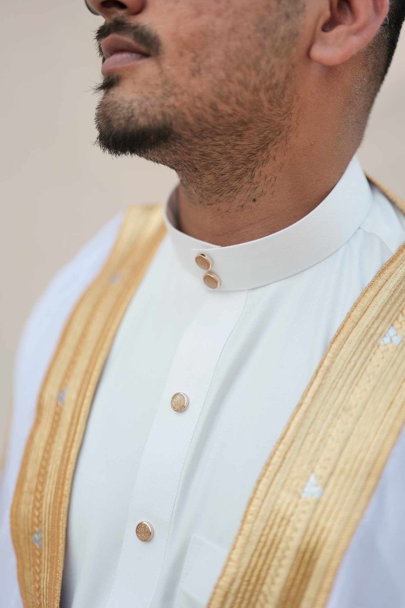 Bisht white and gold close up view